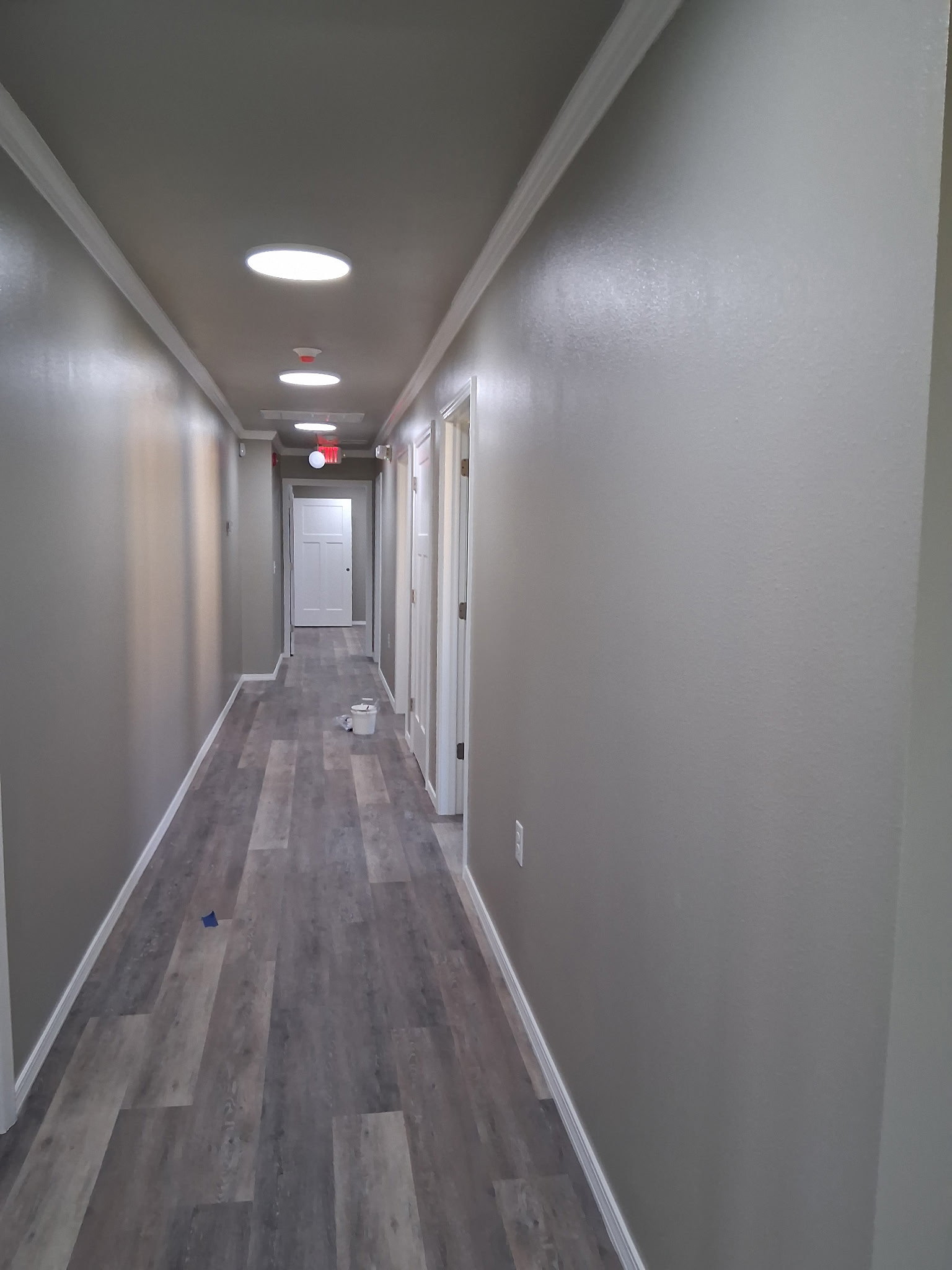 Finished commercial hallway with crown molding, recessed lighting, and vinyl plank flooring
